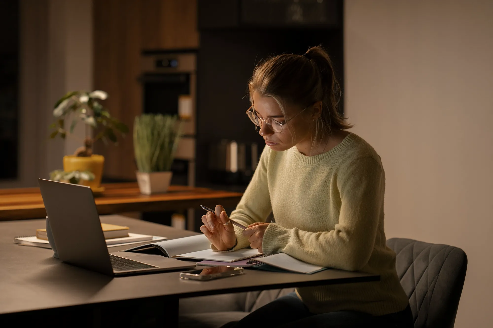 Učitelka se večer doma vzdělává online s notebookem a poznámkami